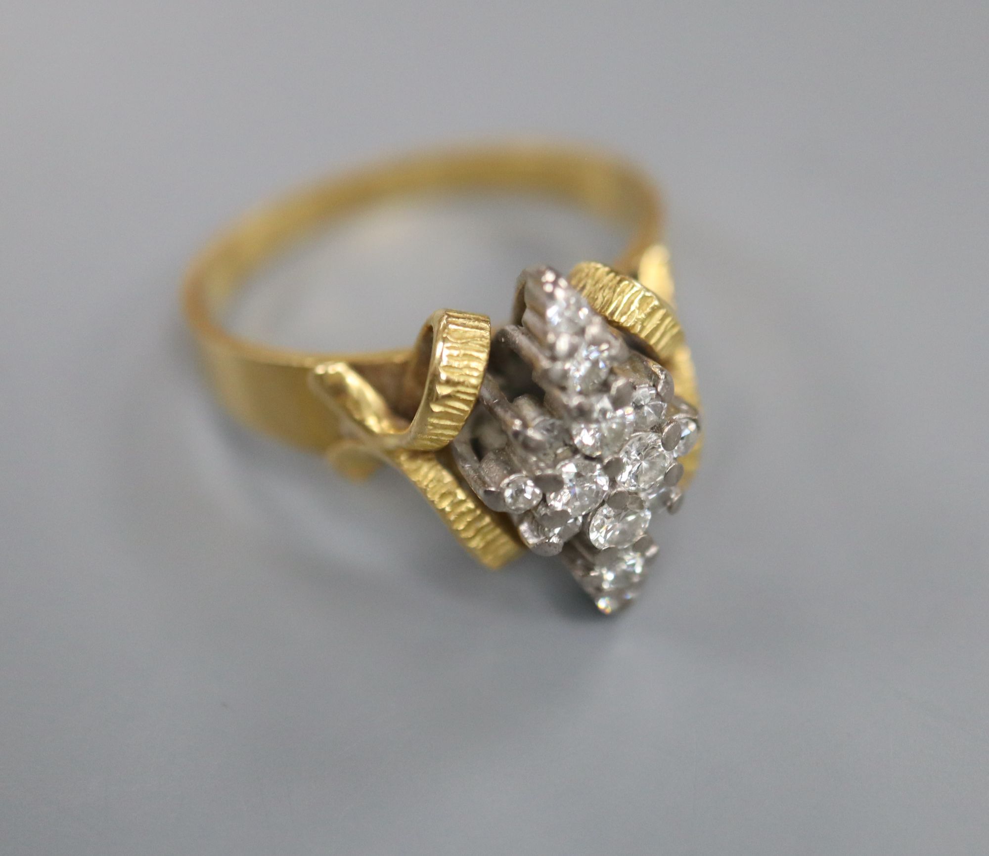 An 18ct and diamond cluster dress ring, in a raised setting, size Q/R, gross 5.9 grams.
